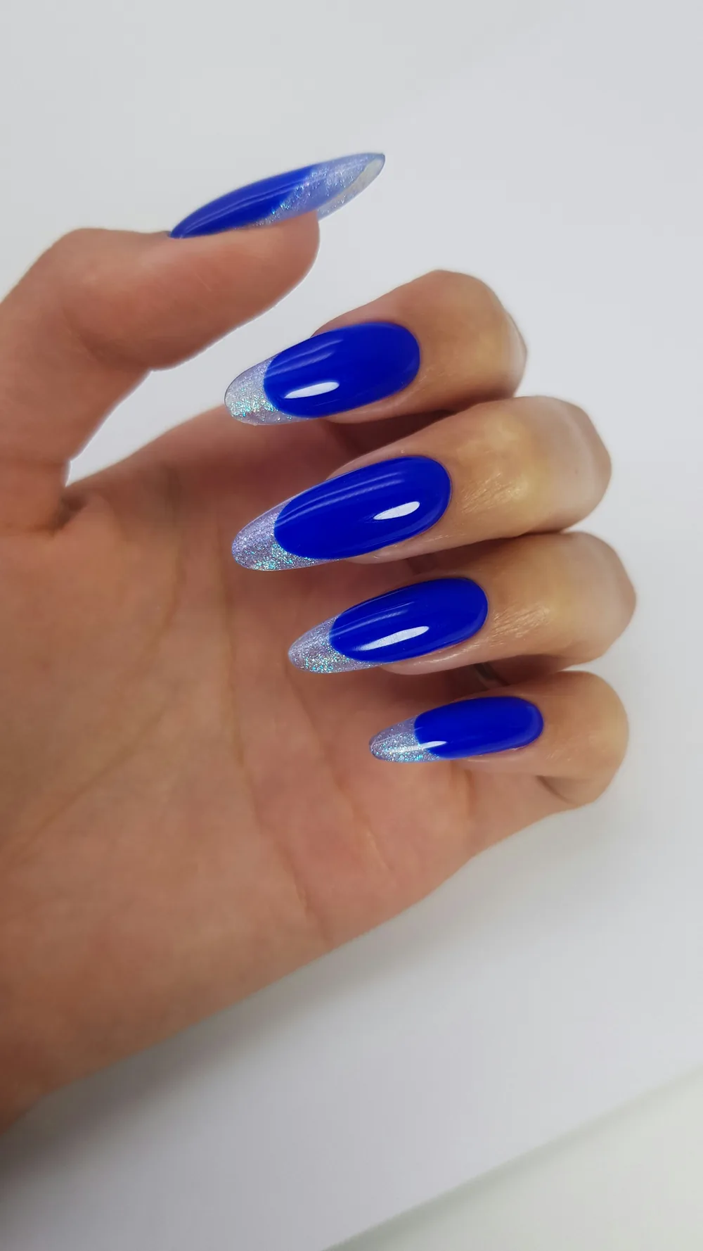 Uñas almendradas largas en azul eléctrico con punta francesa plateada