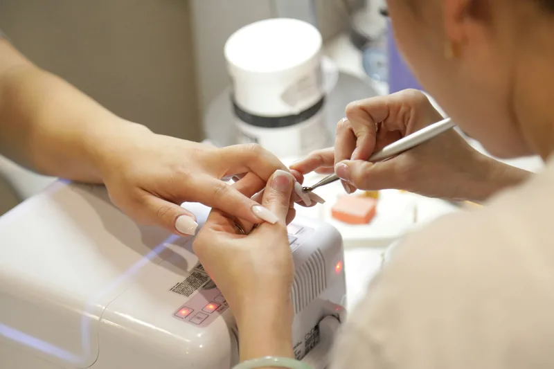 Una manicurista trabaja las uñas de una clienta en el salón